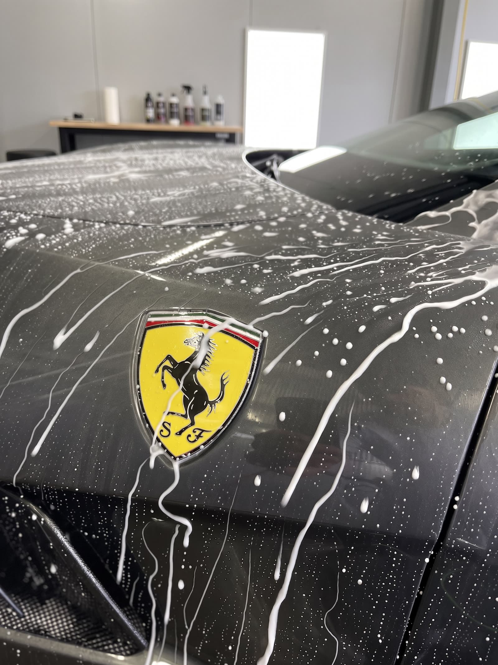 Ferrari mit Aktivschaum und sichtbarem Ferrari-Wappen auf der Haube