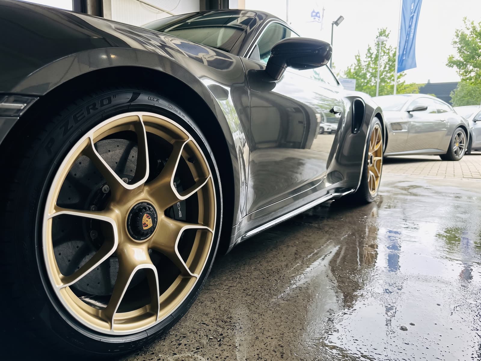 Porsche 992 Turbo S mit Gold-Felgen vor StarWash