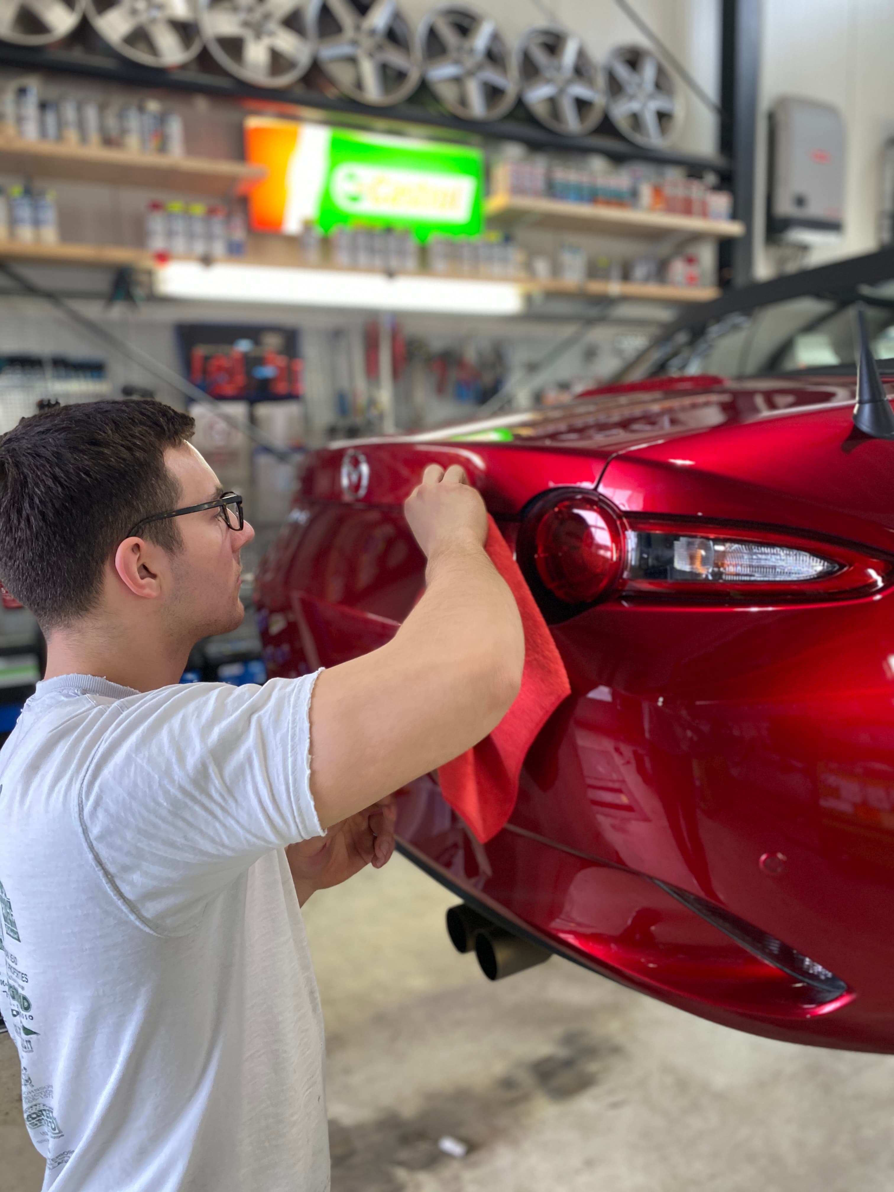 Mitarbeiter poliert Mazda MX-5 in der StarWash Aufbereitung Münster