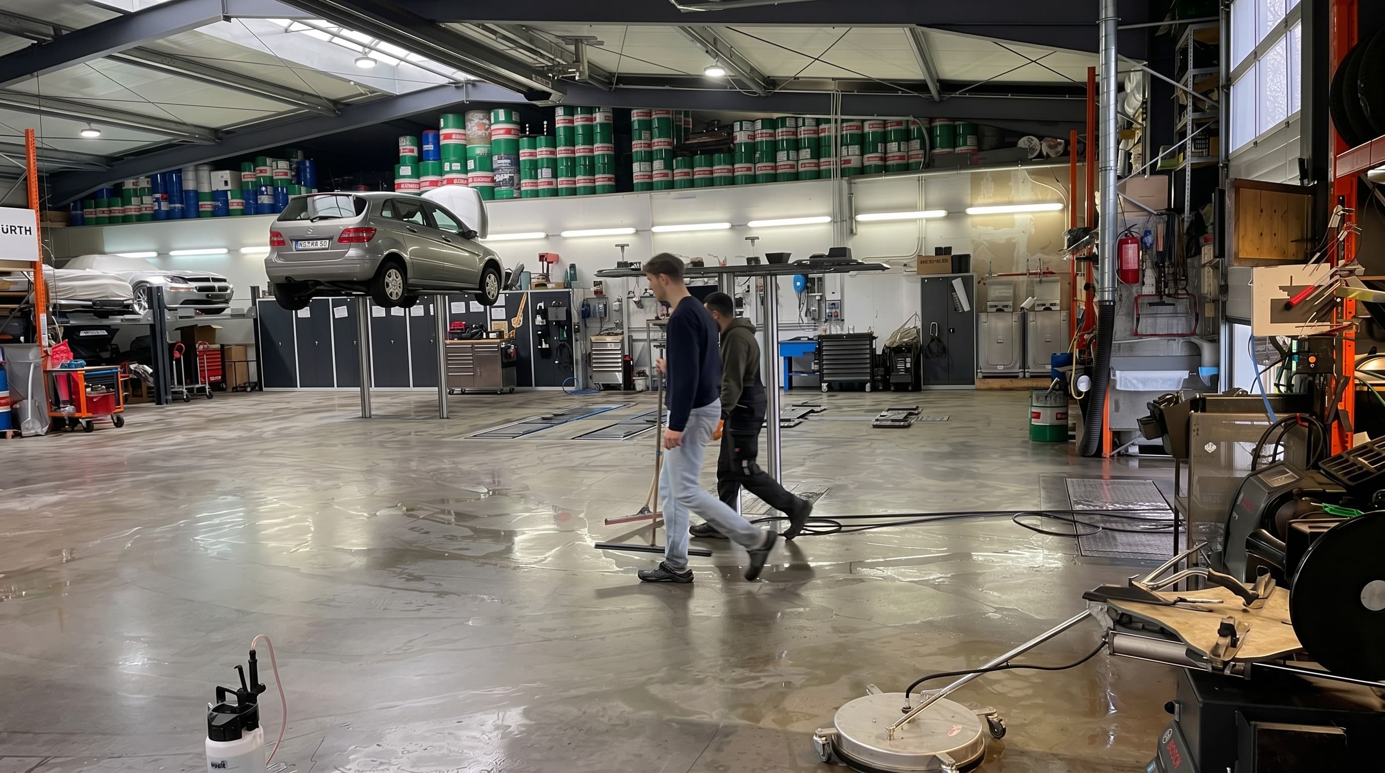 StarWash Werkstatt Münster. Mercedes auf Hebebühne mit Mechanikern bei der Arbeit